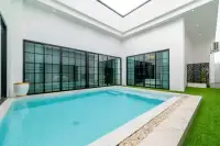 3 Bedroom House for Sale & Rent at PCK Villa private indoor courtyard pool with floor-to-ceiling black-framed glass doors and green lawn