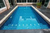 4 Bedroom House for Sale & Rent in Bang Lamung close-up of blue mosaic-tiled private pool with white pebble surround