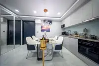 2 Bedroom Condo for Sale at Grand Solaire Noble, modern kitchen with integrated appliances and dining table set for four.