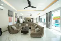 8 Bedroom House for Rent in Na Kluea spacious living room with sectional sofa and pool view