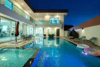 8 Bedroom House for Rent in Na Kluea poolside with floats and lounge chairs at dusk