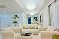 3 Bedroom House for Sale in Na Kluea open-plan lounge with beige sofas, crystal chandeliers, and dining table