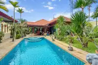 3 Bedroom House for Sale in Na Kluea with tiled pool, red-roofed villa and lush tropical garden