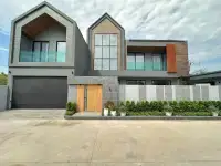 4 Bedroom House for Sale in Na Kluea modern two-story exterior with wooden door and landscaped entrance