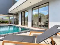 4 Bedroom House for Sale in Na Kluea poolside patio with lounge chairs and sliding glass doors to interior