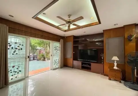 5 Bedroom House for Rent in Na Kluea living room with wood paneling, ceiling fan, and TV entertainment unit