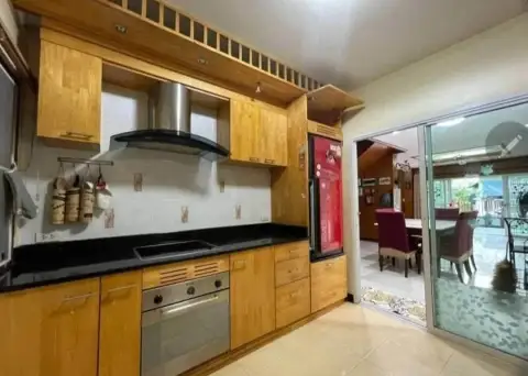 5 Bedroom House for Rent in Na Kluea wooden kitchen with black countertop, oven, and range hood