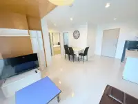 2 Bedroom Condo for Sale at Natureza Art living area with TV, dining table, and entrance hallway view