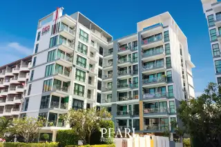 Neo Condo exterior view of modern building with balconies and large windows under a clear blue sky.