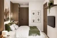 1 Bedroom Condo for Sale at Siam Oriental Beach: Bedroom with a bed, wall-mounted TV, and botanical framed prints.