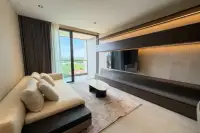 1 Bedroom Condo for Rent at Panora Estuaria modern living room with cream sofa, marble coffee table, TV wall unit and city view balcony