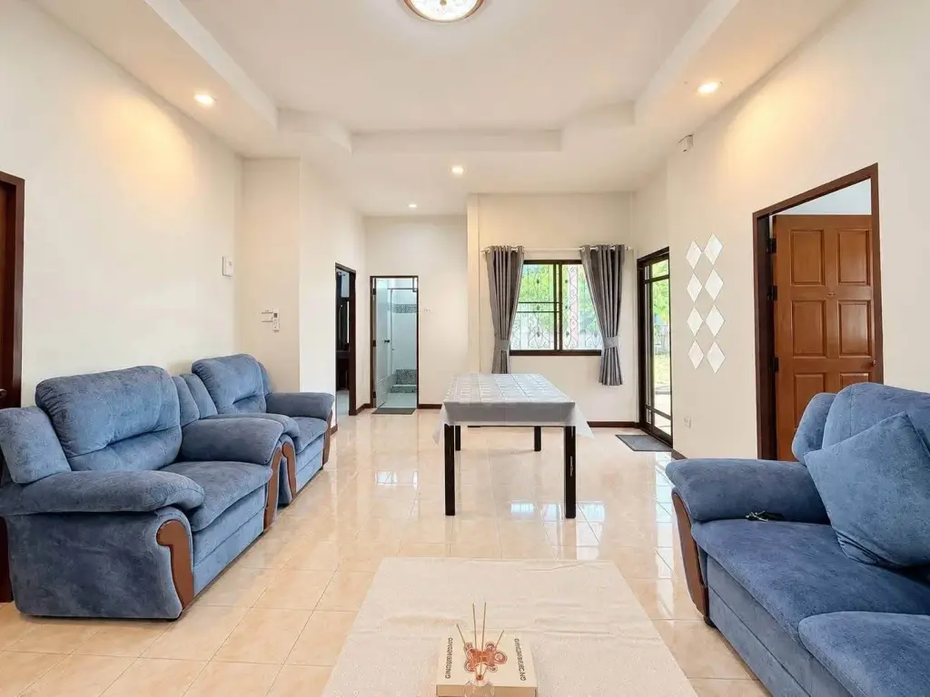 2 Bedroom House for Rent at Noen Plub Wan Village spacious living room with blue sofas and dining table