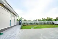 3 Bedroom House for Sale & Rent in Nong Pla Lai side yard with tiled walkway and landscaped garden