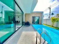 3 Bedroom House for Rent in Nong Pla Lai poolside walkway with glass doors and palm tree landscaping