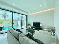 3 Bedroom House for Rent in Nong Pla Lai cozy living area with TV and sliding doors to pool