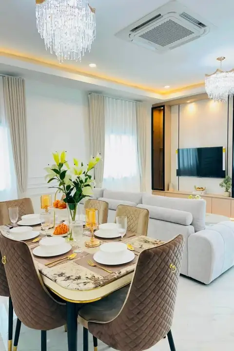 3 Bedroom House for Sale in Nong Prue dining table with floral centerpiece beside plush sofa