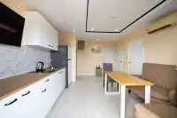 2 Bedroom Condo for Sale at Nordic Residence open kitchen with wooden countertop and dining area with sofa