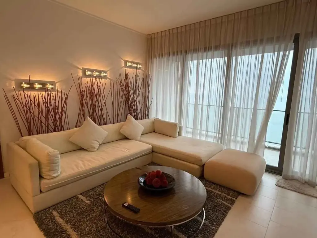 2 Bedroom Condo for Rent at Northpoint living room with cream sectional sofa and sea-view balcony windows