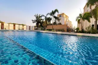 La Royale Beach modern fitness center with exercise equipment, large windows, and spiral staircase visible outside.