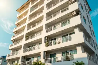 Beach and Mountain Condominium exterior showing multiple floors with balconies, windows, and air conditioning units.