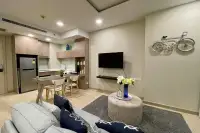 1 Bedroom Condo for Sale at Cetus Beachfront living room with gray sofa, open kitchen, stainless steel fridge, and bicycle wall art