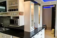 2 Bedroom Condo for Rent at Wongamat Privacy kitchen with black granite countertop, mosaic tile backsplash, microwave and open shelves
