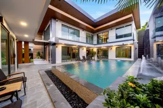 M Mountain Village private pool with water fountain sunloungers and two-storey villa at dusk