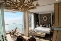 1 Bedroom Condo for Sale at Cetus Beachfront master bedroom with antler chandelier, decorative headboard wall, and ocean balcony view