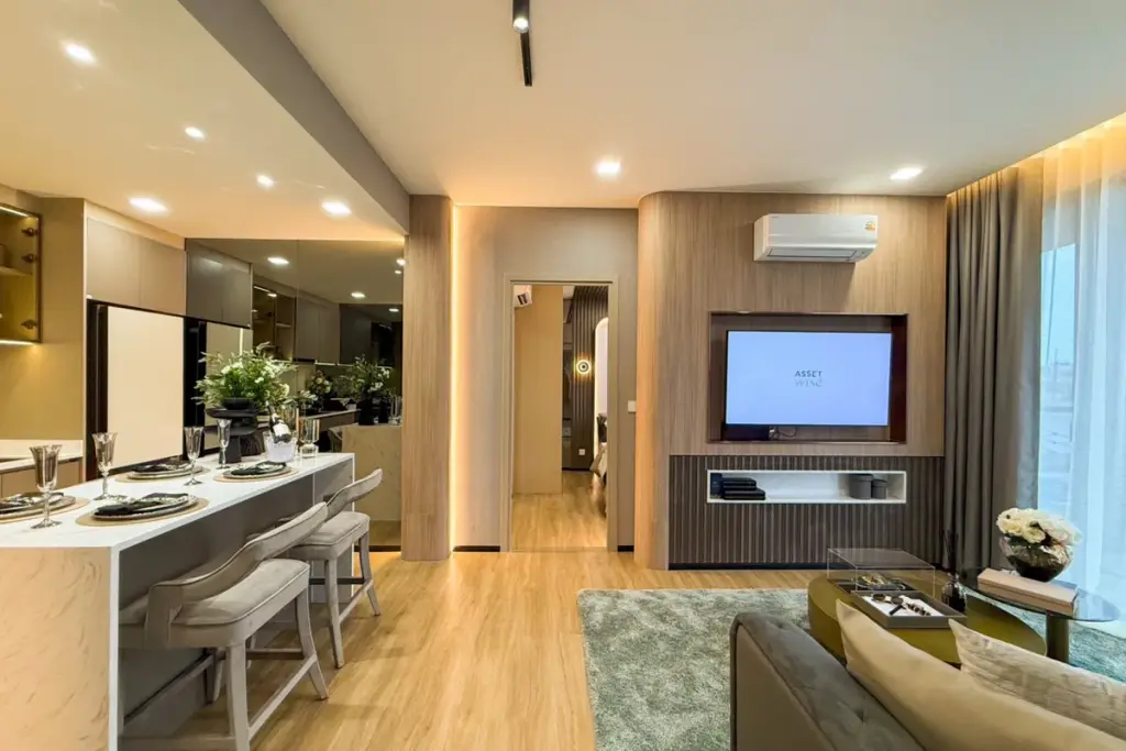 2 Bedroom Condo for Sale at Aquarous Jomtien Pattaya open-plan living and dining area with wood TV feature wall and marble breakfast bar
