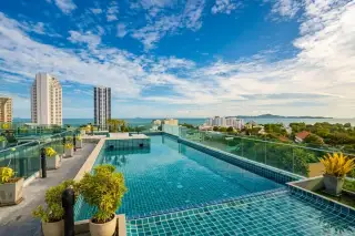 Laguna Bay 1 rooftop terrace with lounge chairs, artificial grass, potted plants, and city/ocean views.