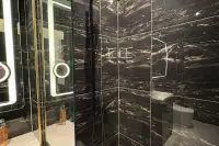 Studio Condo for Sale at Grand Solaire Noble glass-enclosed walk-in shower with black marble tiles and matte black rain showerhead