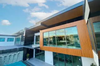 M Mountain Village modern exterior facade with wood cladding large glass windows and poolside view