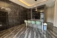 6 Bedroom House for Sale in Bang Lamung bar area with black marble walls, green velvet stools, and pendant lights.