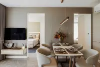 2 Bedroom Condo for Sale at The Coral Pattaya: dining area with set table, TV, and glimpses into two separate bedrooms.