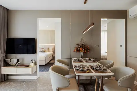 2 Bedroom Condo for Sale at The Coral Pattaya: dining area with set table, TV, and glimpses into two separate bedrooms.