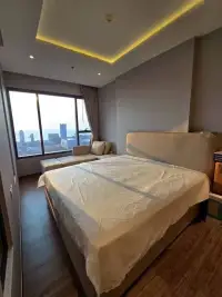 2 Bedroom Condo for Sale at Once Pattaya bedroom with king bed, lounge seating, and floor-to-ceiling city view window