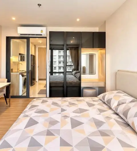 Studio Condo for Rent at Once Pattaya bedroom with mirrored wardrobe and view into kitchen