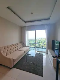 1 Bedroom Condo for Rent at One Tower Pratumnak living room with beige sofa, glass table and balcony sea view