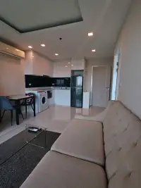 1 Bedroom Condo for Rent at One Tower Pratumnak open-plan living room, kitchen and dining area with white cabinetry