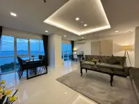 2 Bedroom Condo for Rent at One Tower Pratumnak living room with dining table and sea view at dusk