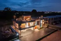 5 Bedroom House for Sale at Opal Village illuminated exterior view at night with rooftop lounge area