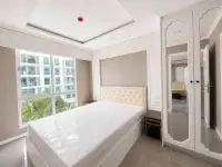 2 Bedroom Condo for Sale at The Orient Resort & Spa bedroom with tufted headboard, mirrored wardrobe and city view window