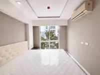 2 Bedroom Condo for Sale at The Orient Resort & Spa bright bedroom with air conditioning unit and palm tree view window