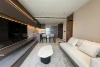 1 Bedroom Condo for Rent at Panora Estuaria open-plan living and kitchen area with dark cabinetry, breakfast bar and marble coffee table