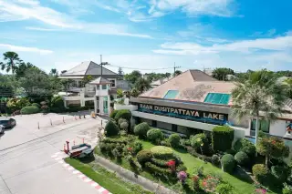 Baan Dusit Pattaya Lake 2 outdoor swimming pool with blue tiles, stone elephant statues, and a modern house.