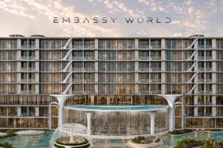 Embassy World condo exterior facade with glass balconies, waterfall feature pool, and fountain at dusk in Pattaya