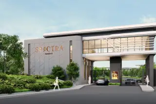 Spectra Residence gated entrance with branded signage wall, modern two-storey clubhouse facade and lush landscaping in Pattaya