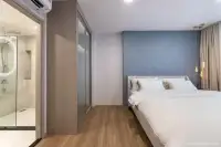 1 Bedroom Condo for Sale at Aquarous Jomtien Pattaya: Living area with a sofa, side table, TV, and large windows with curtains.