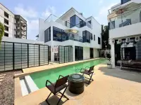 4 Bedroom House for Sale at Palm Spring villa Pattaya modern exterior with green lap pool and poolside seating area