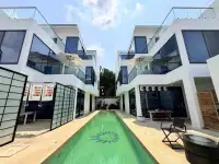 4 Bedroom House for Sale at Palm Spring villa Pattaya twin villa buildings framing a long green swimming pool